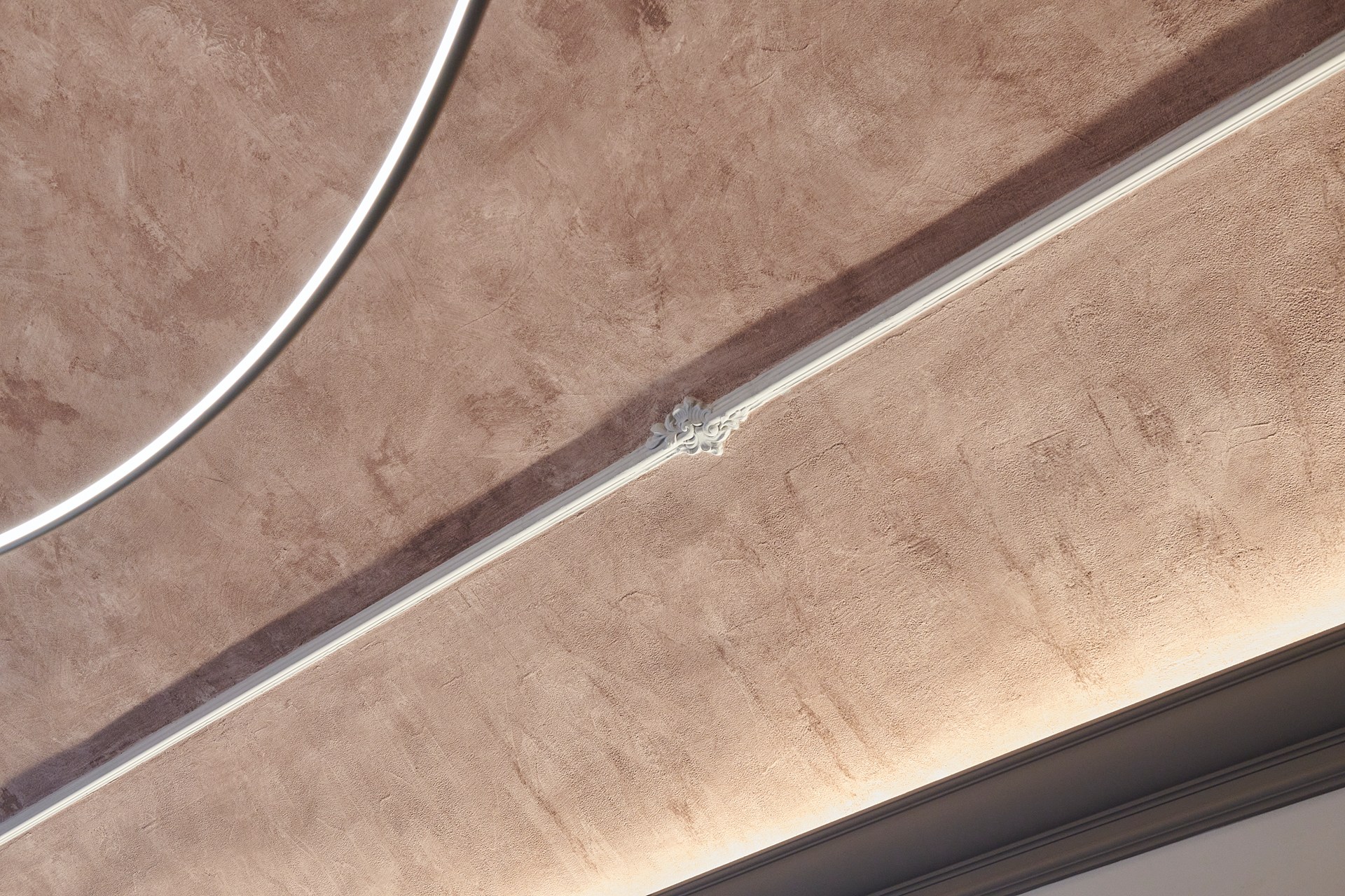 Decorative chair rail accentuating wall proportions and enhancing the textured ceiling with integrated lighting.