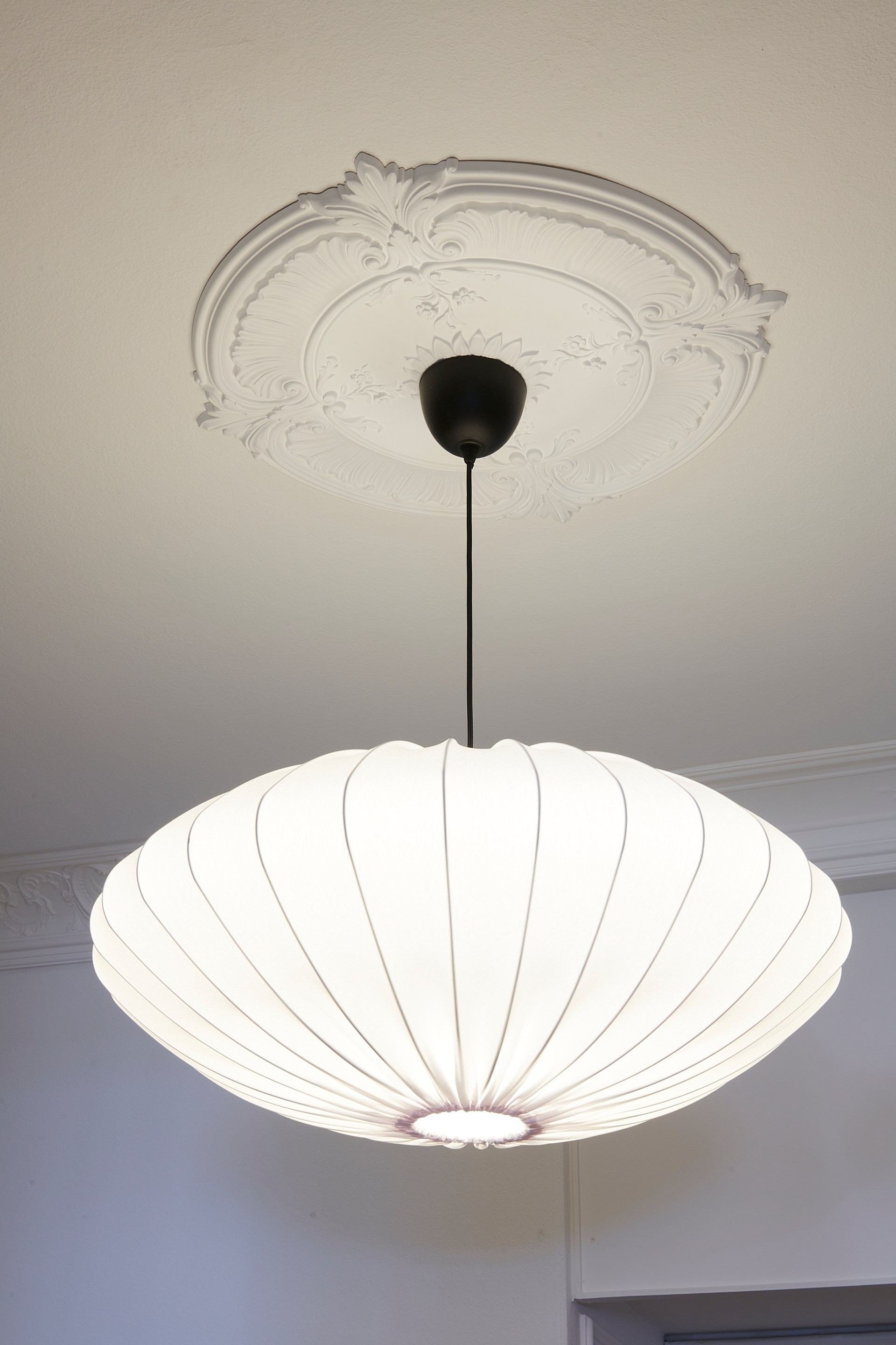 Ornate ceiling rose with sculpted detailing, paired with a pendant light to enhance classic ceiling decoration.